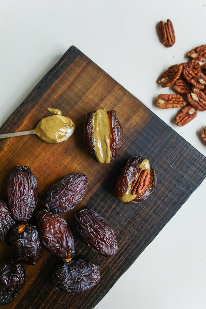Delicious close-up of dates stuffed with pecan nuts on a wooden board.