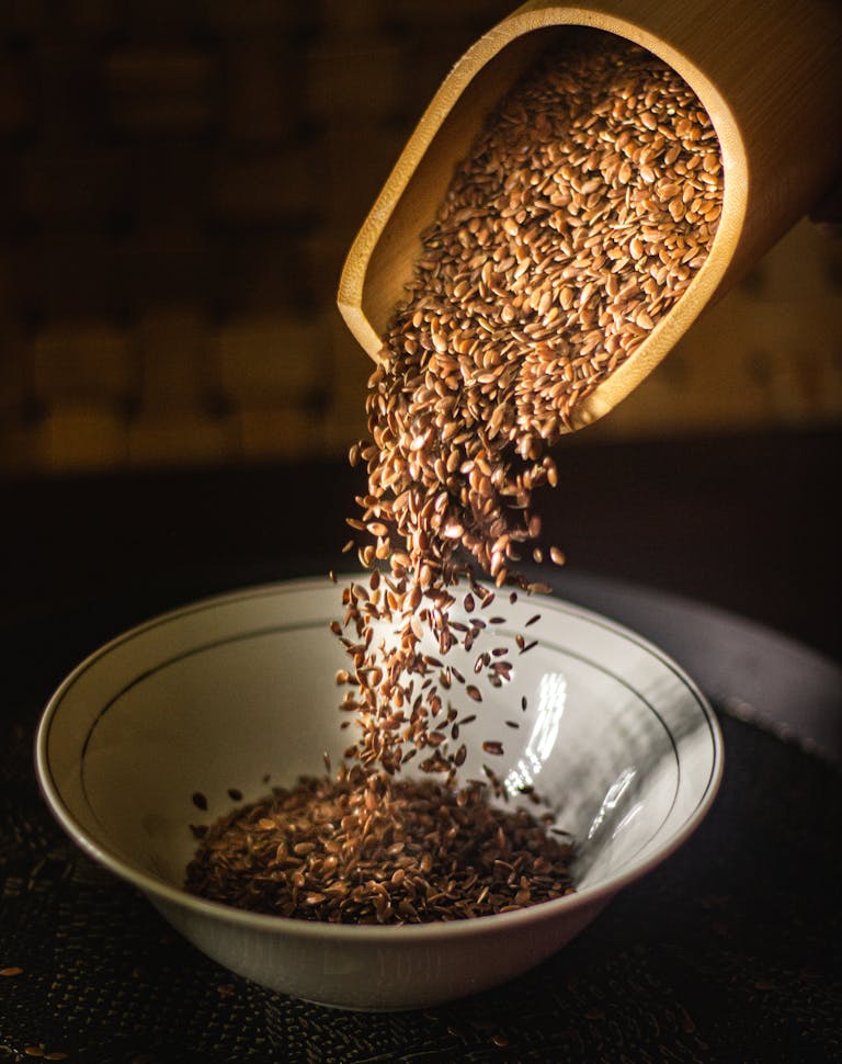 Flax seeds being poured into a bowl, highlighting a nutritious breakfast option.